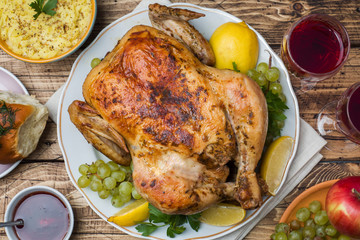 Baked chicken, mashed potatoes and wine glasses for dinner on the festive table.