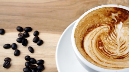 Cappuccino and latte art on the wood table. Free hand pouring some milk on the coffee. Morning breakfast with coffee.