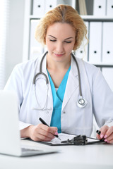 Doctor woman at work. Physician filling up medical history records form at the desk. Medicine, healthcare  concept