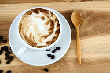 Cappuccino and latte art on the wood table. Free hand pouring some milk on the coffee. Morning breakfast with coffee.