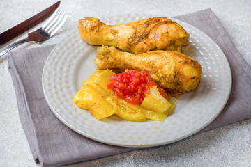 Baked chicken leg Shin with vegetables tomato zucchini on a plate.