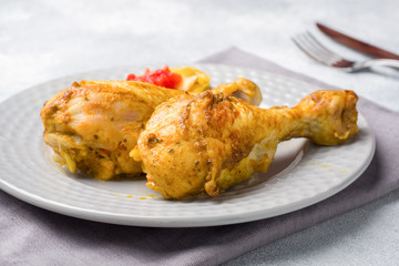 Baked chicken leg Shin with vegetables tomato zucchini on a plate.