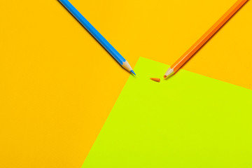 Colorful pencils on a bright green paper background
