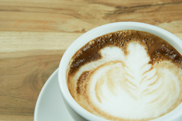 Cappuccino and latte art on the wood table. Free hand pouring some milk on the coffee. Morning breakfast with coffee.
