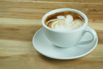Cappuccino and latte art on the wood table. Free hand pouring some milk on the coffee. Morning breakfast with coffee.