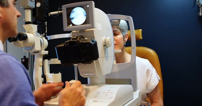 Optometrist examining patient eyes with autorefractors 4k