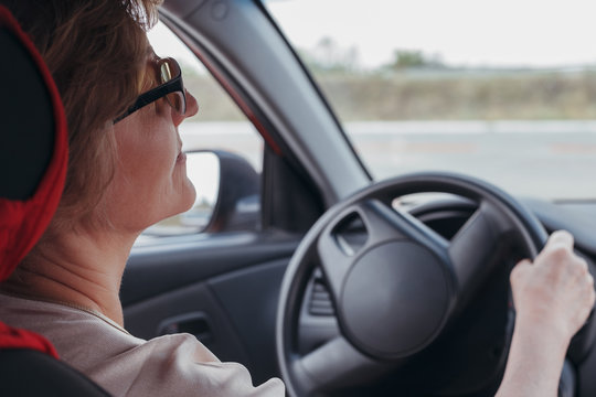 The Elderly Woman Is Driving The Car