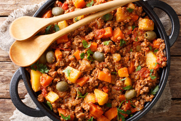 Picadillo Recipe Ground beef, carrot and potatoes cooked in a tomato sauce closeup on a pan. horizontal top view - obrazy, fototapety, plakaty