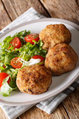 Danish Breaded Pork Patties Karbonader served with fresh salad close-up. vertical