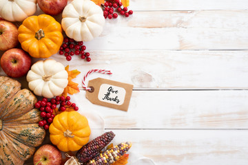 Top view of  Autumn maple leaves with Pumpkin and red berries on white wooden background....