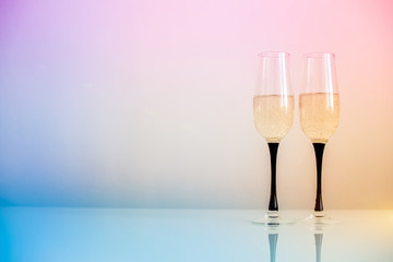     Two glasses of champagne stand on a white table 