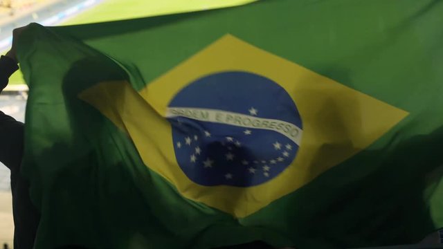 Brazilian family with child waving national flag, cheering for football team