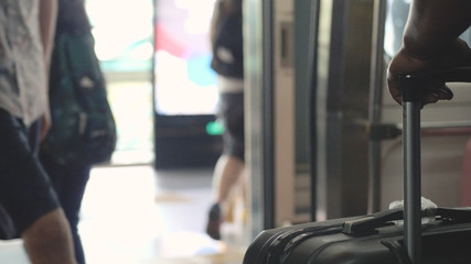 People walking from a subway view on suitcase on a foreground. Doors open