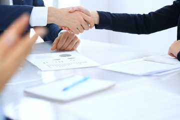 Group of business people or lawyers shaking hands finishing up a meeting , close-up. Success at negotiation and handshake concepts