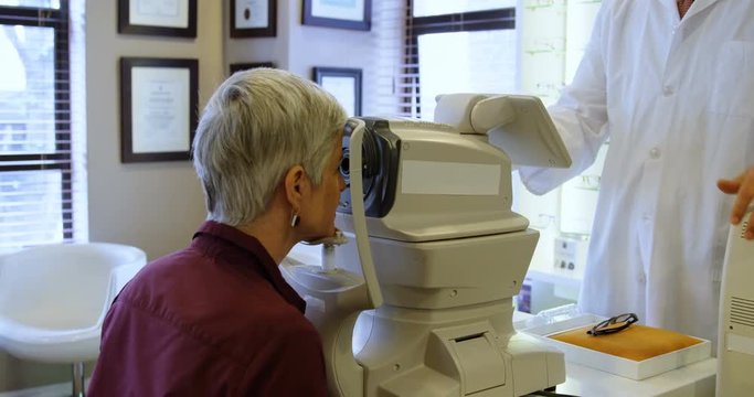 Optometrist examining patient eyes with autorefractors 4k
