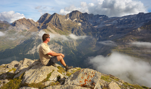 Resting tourist on the stony ridge with mountains on backround, Pyrenees