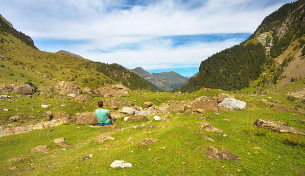 Resting tourist on the stony meadow in the mountain valley, Pyrenees