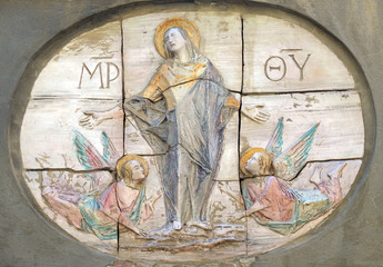 Obraz na płótnie Canvas Virgin Mary relief on the facade in Lucca, Tuscany, Italy 
