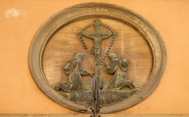 Crucifixion, relief on house facade in Lucca, Tuscany, Italy 