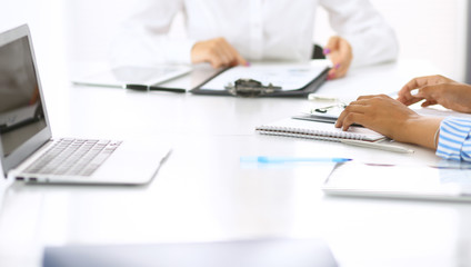 Group of business people at meeting in office, close-up. Team of two women discussing deal. Negotiation concept