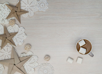 Cosy Christmas composition with coffee, marshmellows, paper stars, chrochet doilies on light...