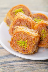 Traditional arabic dessert baklava with cashew, walnuts and cardamom with an eucalyptus branch on a wooden table