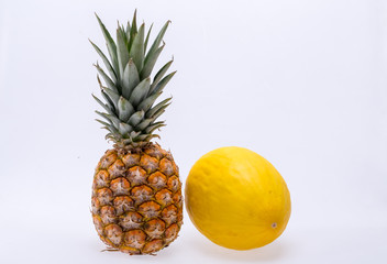 Ripe, fresh pineapple and yellow melon isolated on white background