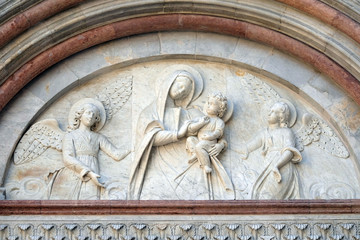 Bass relief representing the Virgin Mary with baby Jesus between angels, Cathedral of S. Martino in Lucca, Tuscany, Italy 