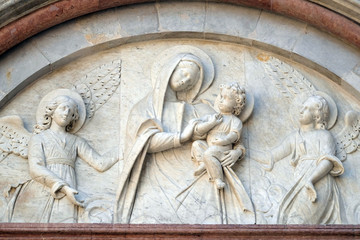 Bass relief representing the Virgin Mary with baby Jesus between angels, Cathedral of S. Martino in Lucca, Tuscany, Italy 
