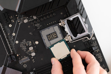 Top view of man hands puts cpu on motherboard, computer parts, Electronics repair and upgrade on...