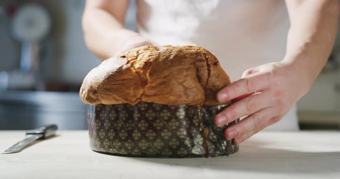 Slow motion of a chef who controls the quality of his Italian panettone by touching it with his hand to understand the softness.