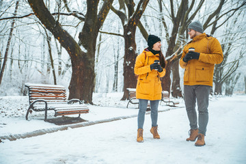 couple walking by snowed city park talking socializing. romantic date in winter time