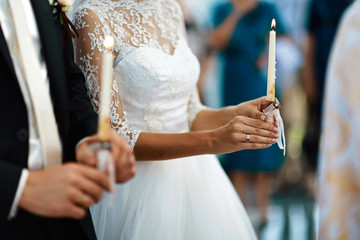 happy bride and stylish groom holding candles wedding ceremony, wedding couple at matrimony in...