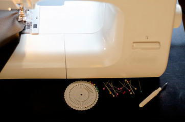  master sews fabric product with a sewing machine on a dark background