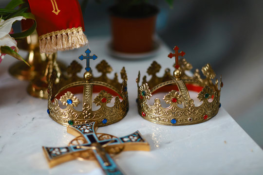 golden crowns and wedding rings at the altar in the church at the wedding couple. traditional religious wedding ceremony