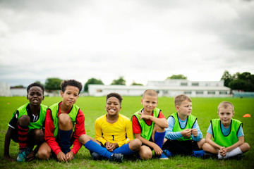 Junior football team sitting on the grass