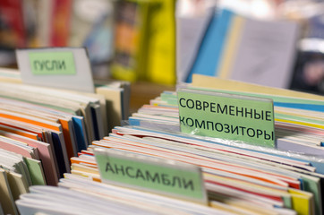 Edges of multi-colored musical notebooks put in a row with inscriptions in Russian 