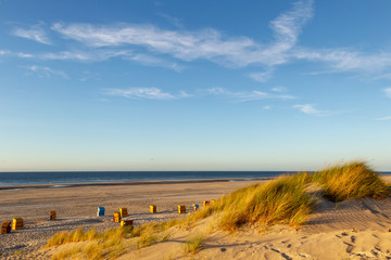 Beach and beach chairs on the East Frisian Island Juist in the North Sea, Germany, in evening light before sunset.