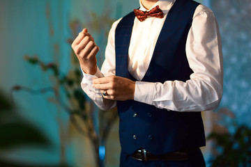Grooms morning preparation, handsome groom getting dressed and preparing for the wedding, wearing...