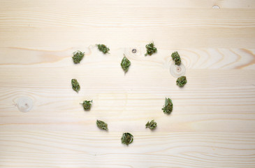 Medical marijuana concept with dry cannabis bud on a wooden background.