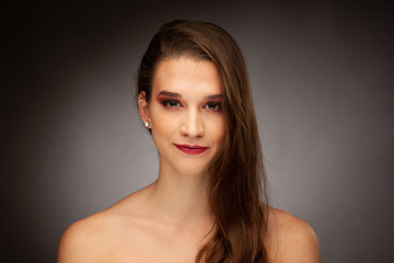 Naklejka premium Beauty portrait of a gorgeous young brunette woman over gray background
