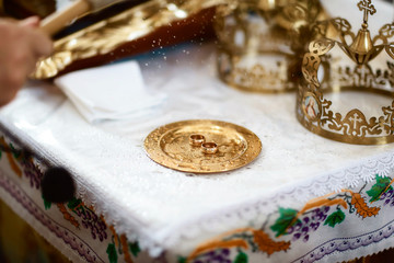 golden wedding rings near the altar in the church for the wedding couple of the traditional religious wedding ceremony