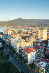 Obraz premium Batumi, Adjara, Georgia - October 2018: cityscape seen from the top of Sheraton sky bar during sunset golden hour with mountains in background