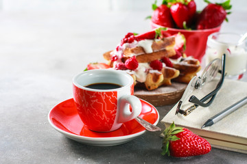 Belgian waffles with creem, raspberries, strawberriesand coffee , top view with copy space.