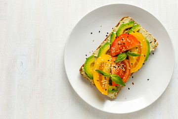 Avocado and tomato toast on plate with copy space