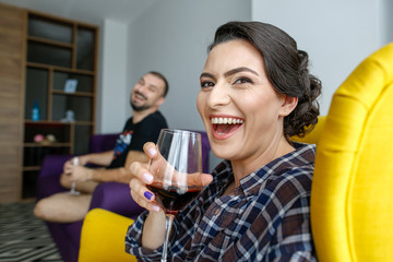 Beautiful couple posing on armchair with wineglass