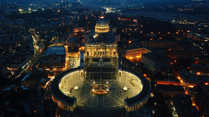 Aerial drone night view of Saint Peter's square in front of world's largest church - Papal Basilica...