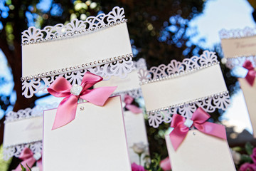 Eleganti segnaposto con fiocchi rosa su sfondo alberi