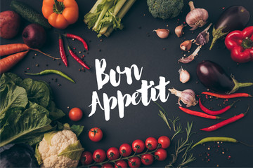 top view of unprocessed vegetables on gray table with bon appetit lettering