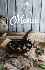 gourmet fried mussels with shells on frying pan and forks on table, healthy menu lettering